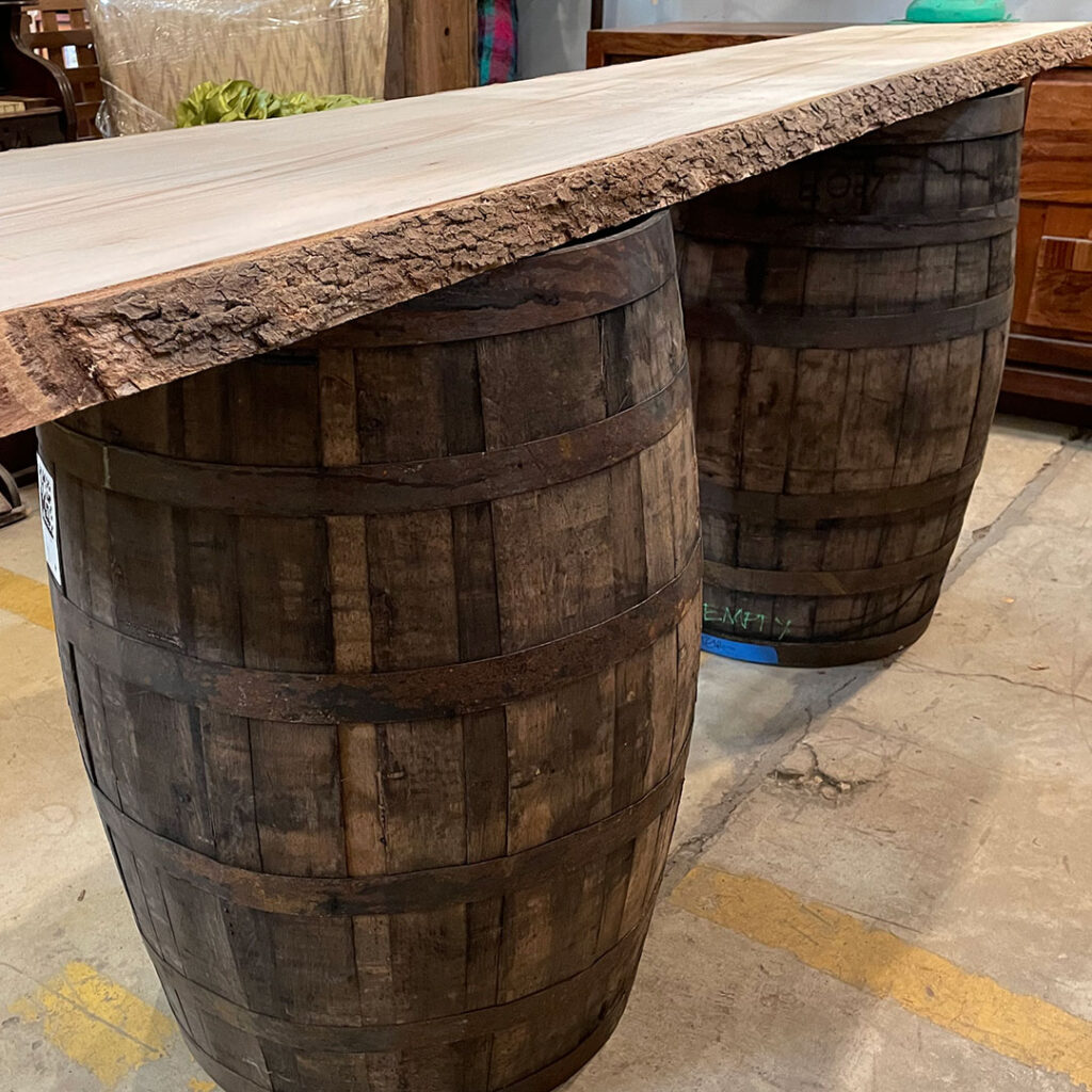 a single wood slab supported by two whiskey barrels
